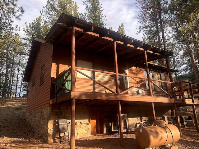 861 Happy Top Trl, Bailey, CO 80421 - rear view of property with a wooden deck, stone siding, and heating fuel