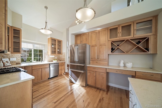 kitchen with lofted ceiling, backsplash, appliances with stainless steel finishes, and pendant lighting