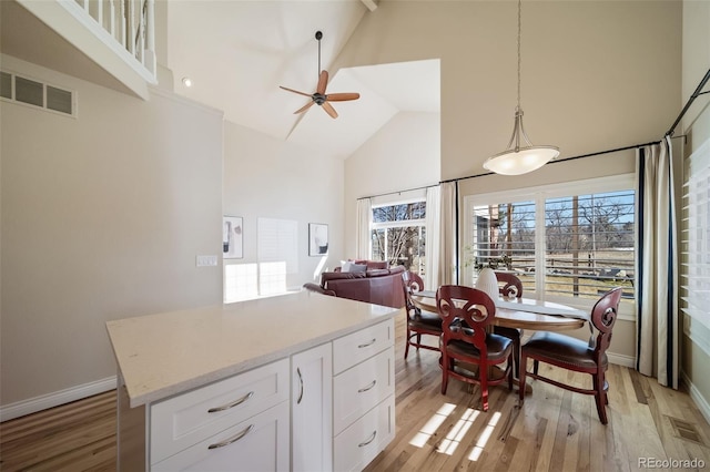 dining room featuring high vaulted ceiling, light wood-type flooring, and ceiling fan