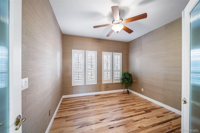 empty room with ceiling fan and light hardwood / wood-style flooring