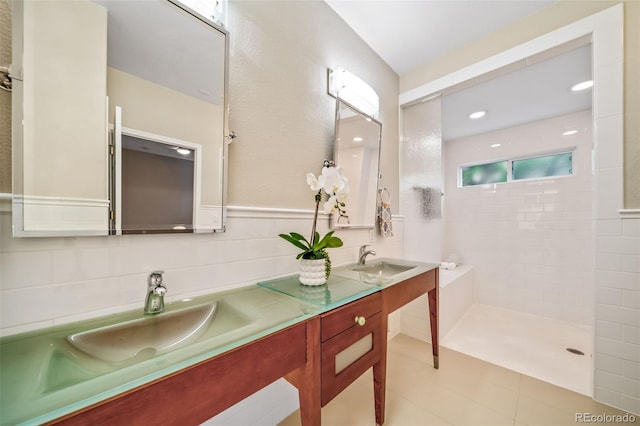 bathroom with vanity, decorative backsplash, and a tile shower