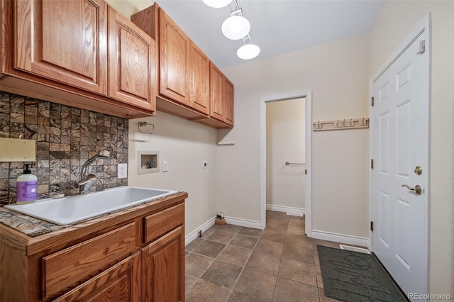 laundry area with dark tile patterned flooring, sink, hookup for a washing machine, electric dryer hookup, and cabinets