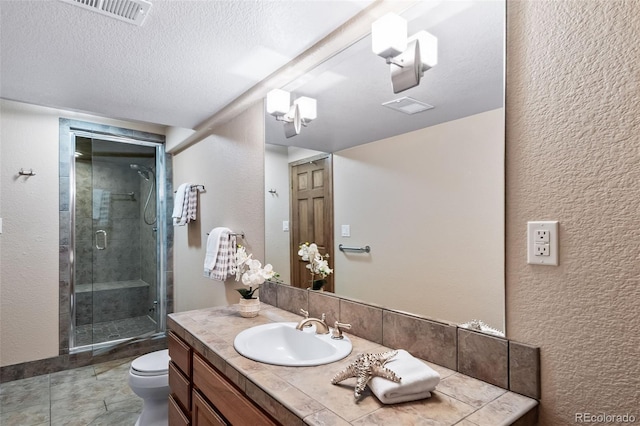 bathroom with toilet, a textured ceiling, walk in shower, and vanity