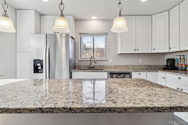 kitchen featuring hanging light fixtures, white cabinetry, appliances with stainless steel finishes, and sink