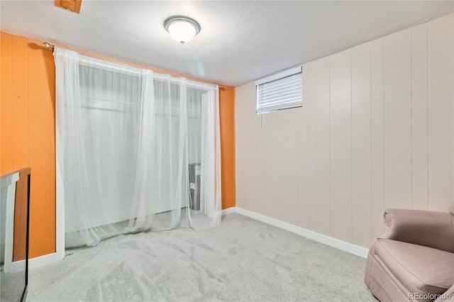 interior space featuring light colored carpet and wood walls