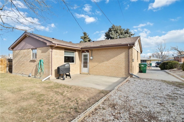 rear view of house with a patio and a lawn