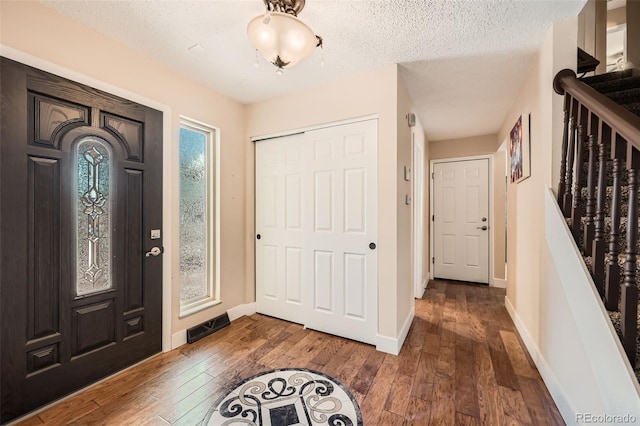 foyer featuring wood-type flooring and a textured ceiling