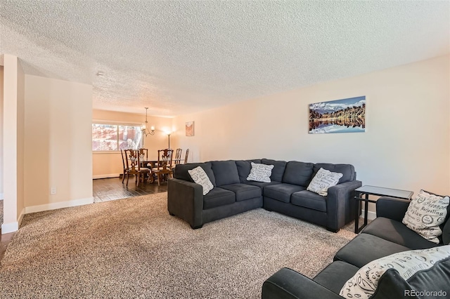 living room with a chandelier, a textured ceiling, and carpet floors