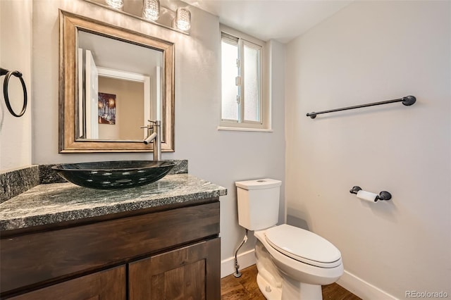 bathroom with hardwood / wood-style flooring, vanity, and toilet