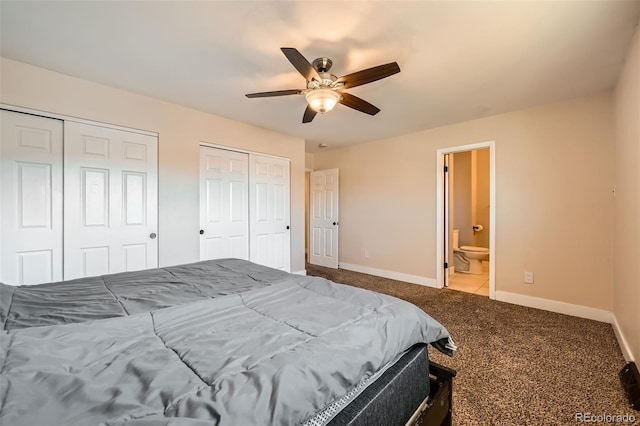 carpeted bedroom featuring ensuite bath, ceiling fan, and multiple closets