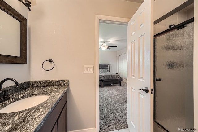 bathroom featuring ceiling fan, a shower with door, and vanity