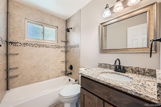 full bathroom featuring vanity, tiled shower / bath combo, and toilet