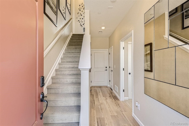 staircase with hardwood / wood-style floors