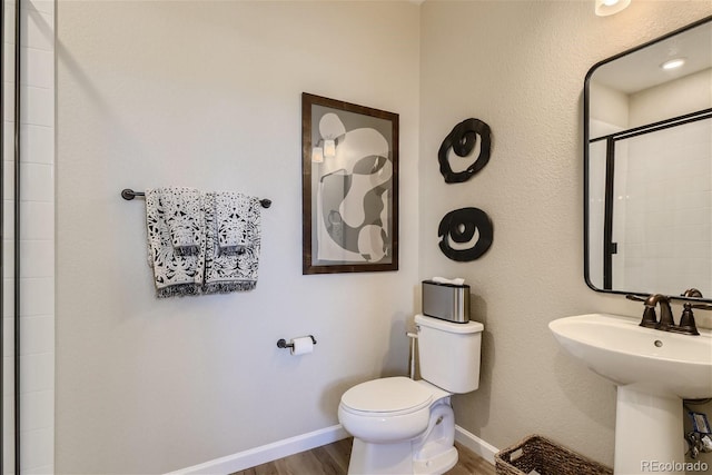 bathroom featuring an enclosed shower, toilet, sink, and hardwood / wood-style flooring