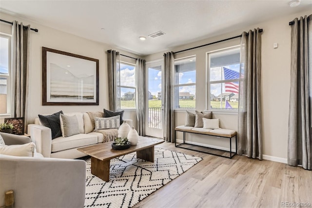 living room with a textured ceiling and light wood-type flooring