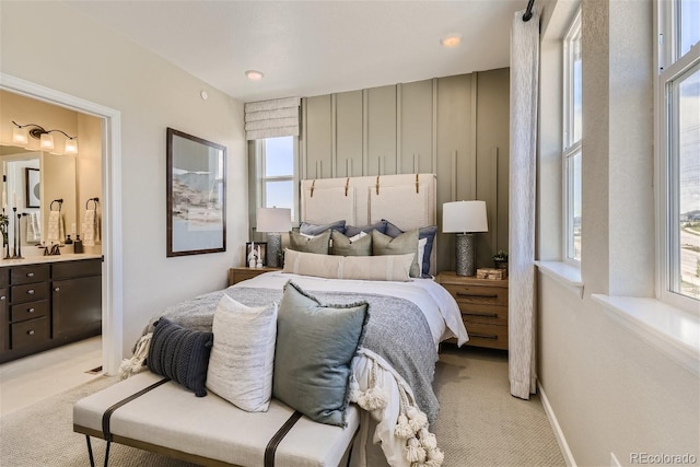 carpeted bedroom with connected bathroom and sink