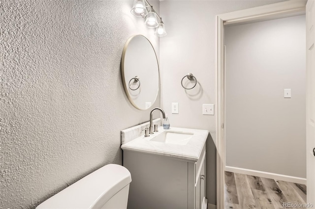 bathroom featuring hardwood / wood-style floors, vanity, and toilet