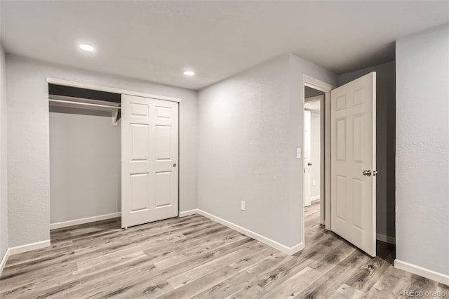 unfurnished bedroom with a closet and light hardwood / wood-style floors