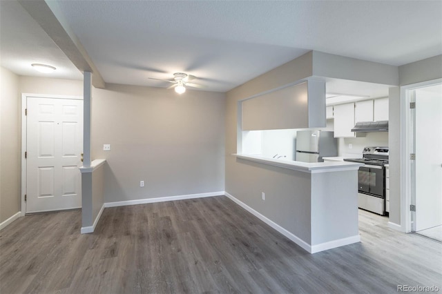 kitchen with a ceiling fan, electric range, freestanding refrigerator, under cabinet range hood, and white cabinetry