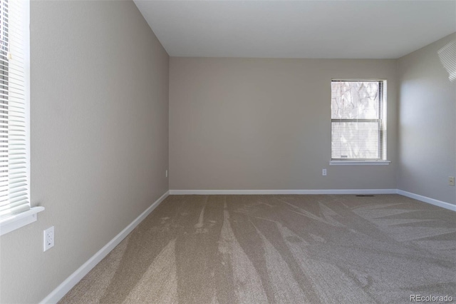 spare room featuring baseboards and carpet