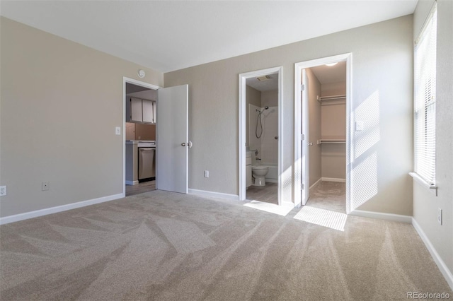 unfurnished bedroom featuring a walk in closet, light colored carpet, a closet, and baseboards