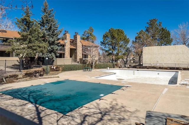 community pool featuring a patio area and fence