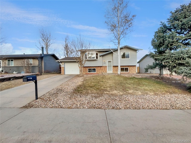 bi-level home featuring driveway, an attached garage, and brick siding