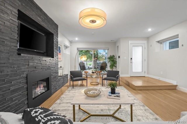 living room with hardwood / wood-style floors and a large fireplace