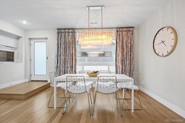 dining space featuring an inviting chandelier and light wood-type flooring