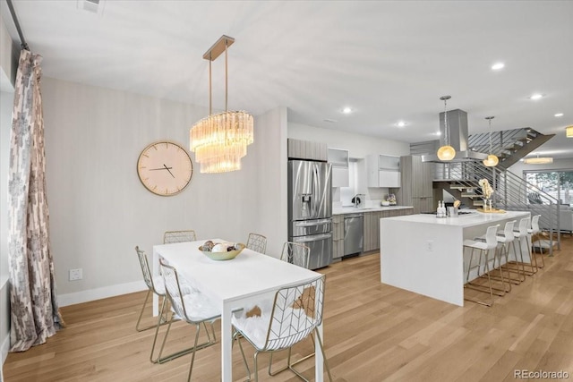 dining room with a notable chandelier and light hardwood / wood-style flooring