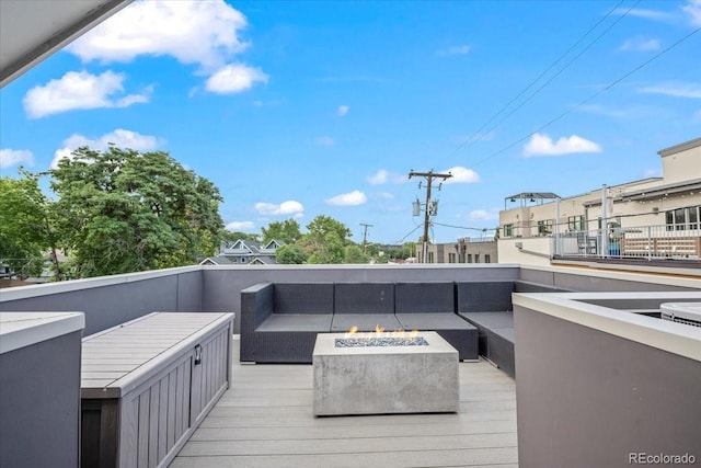 wooden deck featuring an outdoor living space with a fire pit