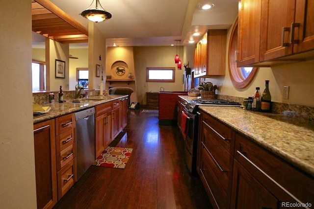 kitchen featuring dishwasher, dark hardwood / wood-style flooring, gas range, decorative light fixtures, and sink