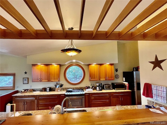 kitchen with stainless steel appliances, sink, kitchen peninsula, hanging light fixtures, and lofted ceiling