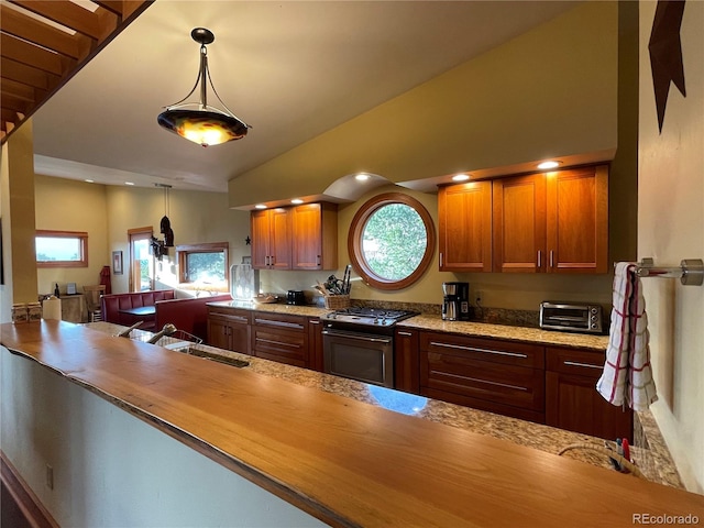 kitchen featuring sink, decorative light fixtures, a healthy amount of sunlight, and stainless steel gas stove