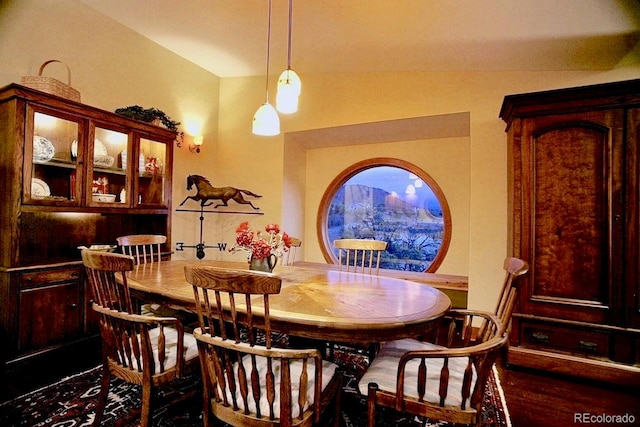 dining area featuring hardwood / wood-style flooring, lofted ceiling, and a mountain view