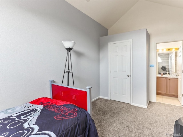 8361 S Upham Way Unit 209, Littleton, CO 80128 - carpeted bedroom featuring vaulted ceiling, ensuite bathroom, and baseboards