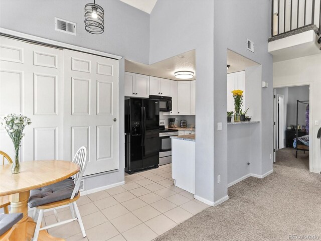 8361 S Upham Way Unit 209, Littleton, CO 80128 - kitchen with black appliances, a high ceiling, white cabinetry, baseboards, and light colored carpet