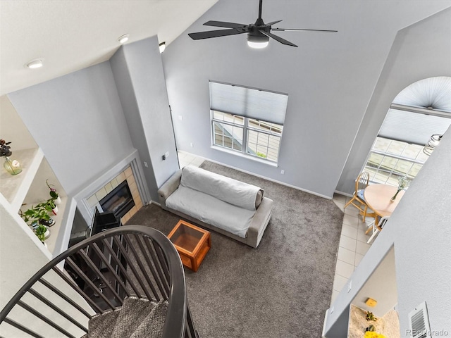8361 S Upham Way Unit 209, Littleton, CO 80128 - living area with a tile fireplace, ceiling fan, healthy amount of natural light, carpet, and vaulted ceiling