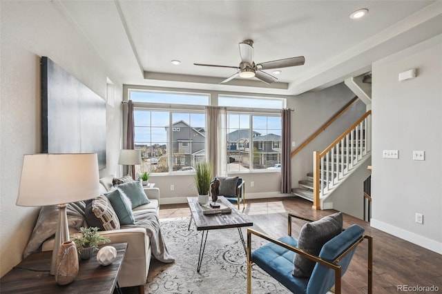 living area featuring stairs, a wealth of natural light, ceiling fan, and wood finished floors