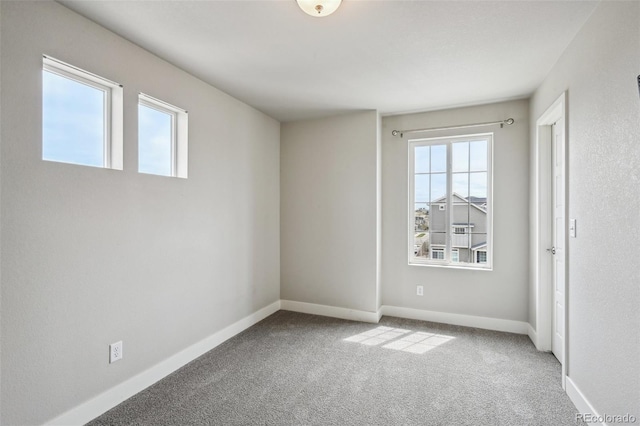 carpeted empty room featuring baseboards