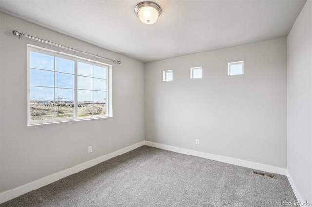 spare room featuring baseboards, carpet flooring, and visible vents