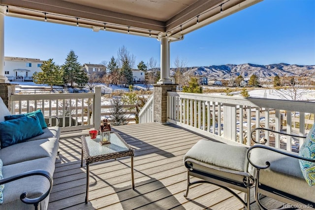 snow covered deck featuring an outdoor hangout area and a mountain view