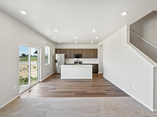 544 97th Ave, Greeley, CO 80634 - kitchen featuring stainless steel refrigerator with ice dispenser, a center island with sink, recessed lighting, open floor plan, and range