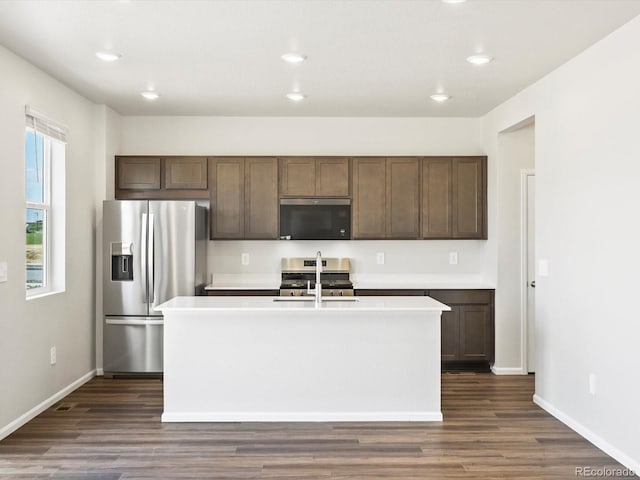 544 97th Ave, Greeley, CO 80634 - kitchen featuring stainless steel appliances, dark wood finished floors, light countertops, a center island with sink, and recessed lighting