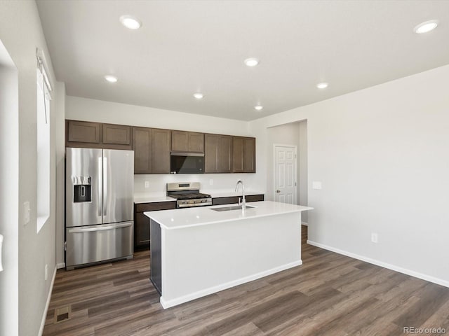 544 97th Ave, Greeley, CO 80634 - kitchen with appliances with stainless steel finishes, dark wood-type flooring, dark brown cabinets, a center island with sink, and recessed lighting
