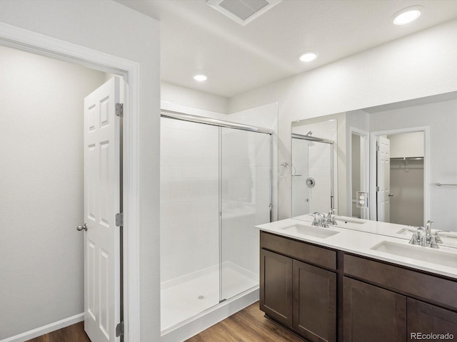 544 97th Ave, Greeley, CO 80634 - full bathroom with a shower stall, wood finished floors, a walk in closet, double vanity, and recessed lighting
