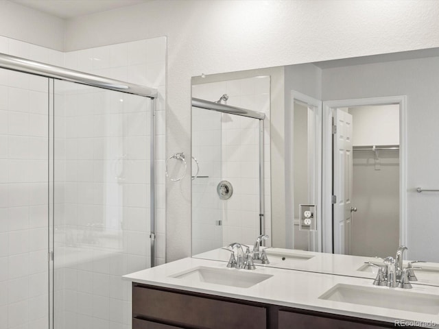 544 97th Ave, Greeley, CO 80634 - full bathroom featuring a stall shower, double vanity, and a walk in closet