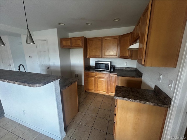 2005 W 86th Ave, Denver, CO 80260 - kitchen with stainless steel microwave, dark countertops, brown cabinets, tile patterned flooring, and recessed lighting