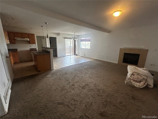 2005 W 86th Ave, Denver, CO 80260 - unfurnished living room featuring a tiled fireplace, light colored carpet, light tile patterned flooring, and a chandelier