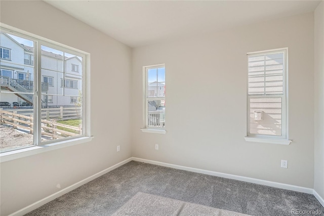 unfurnished room featuring plenty of natural light and carpet floors